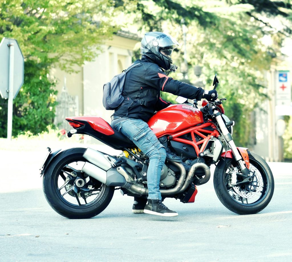 a man riding on the back of a red motorcycle