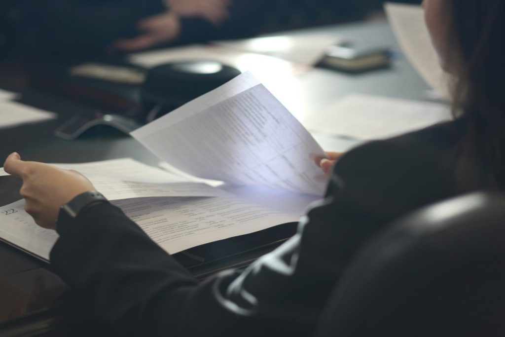 une femme assise à une table en train de lire un journal